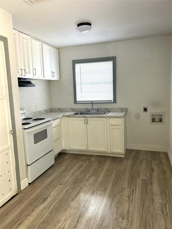 6415 Latta Street, Unit 1 Dallas, TX 75227 - Photo 3 of 5 a kitchen with stainless steel appliances granite countertop a stove a sink and white cabinets with wooden floor