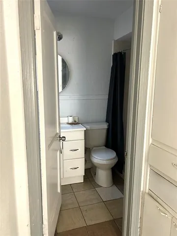 a bathroom with a toilet and a mirror