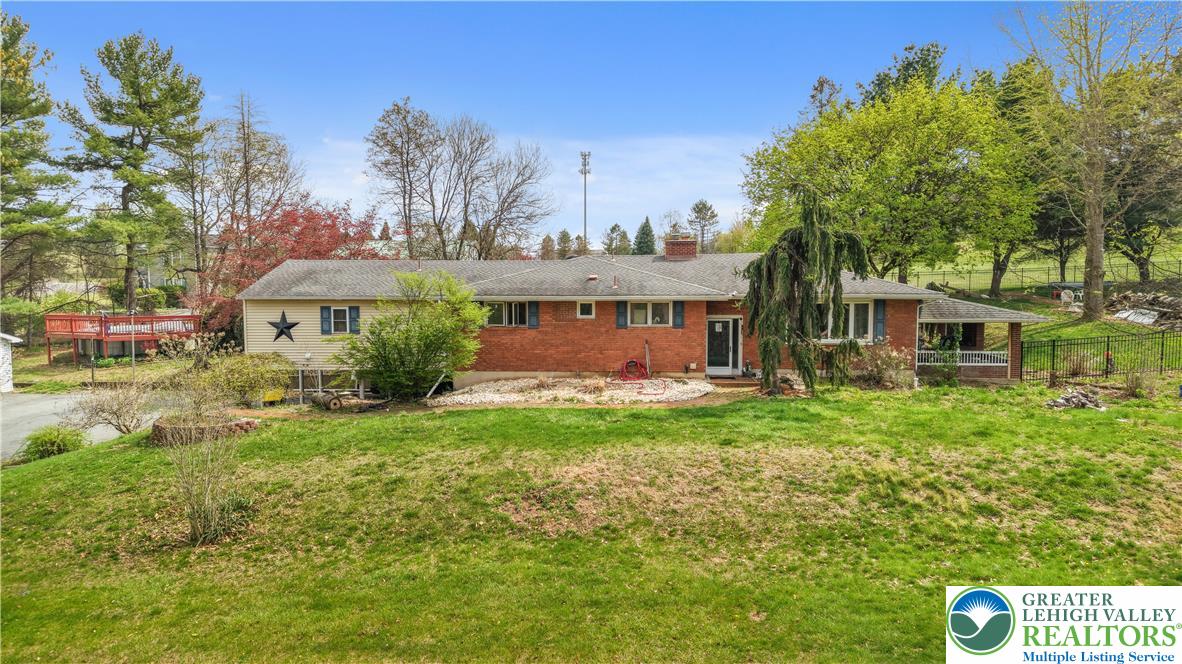 a view of a house with backyard and a tree