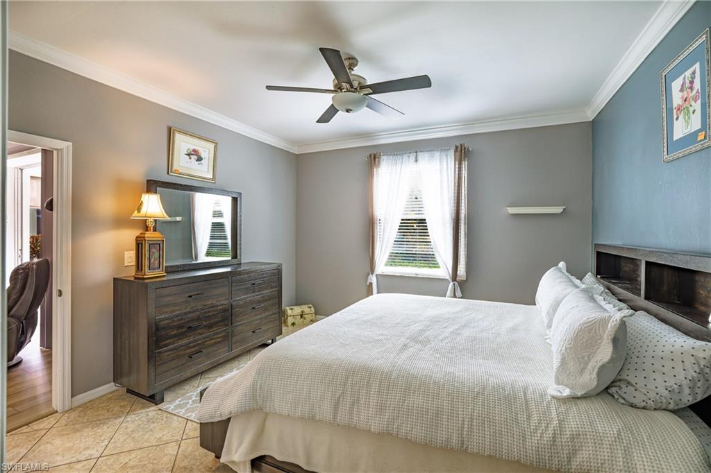 305 Robin Hood Circle, Unit 101 Naples, FL 34104 - Photo 12 of 31 a bedroom with a bed and window with mirror