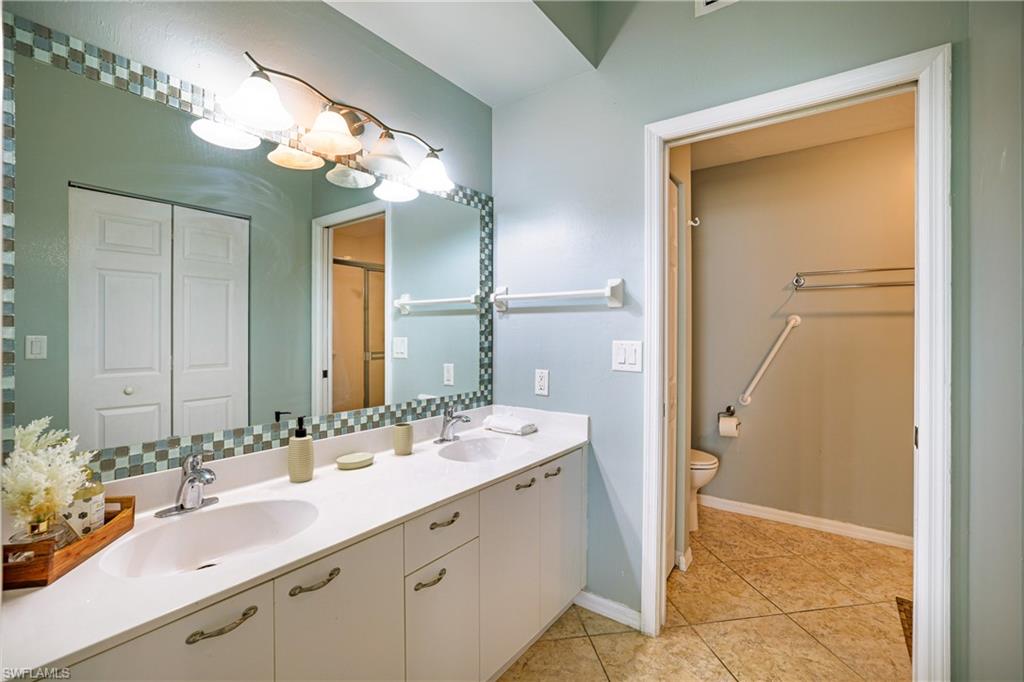 305 Robin Hood Circle, Unit 101 Naples, FL 34104 - Photo 13 of 31 a bathroom with a double vanity sink mirror and vanity