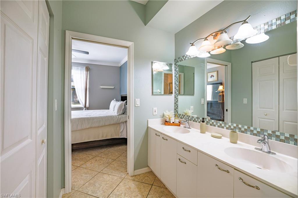 305 Robin Hood Circle, Unit 101 Naples, FL 34104 - Photo 14 of 31 a bathroom with a double vanity sink mirror and bathtub
