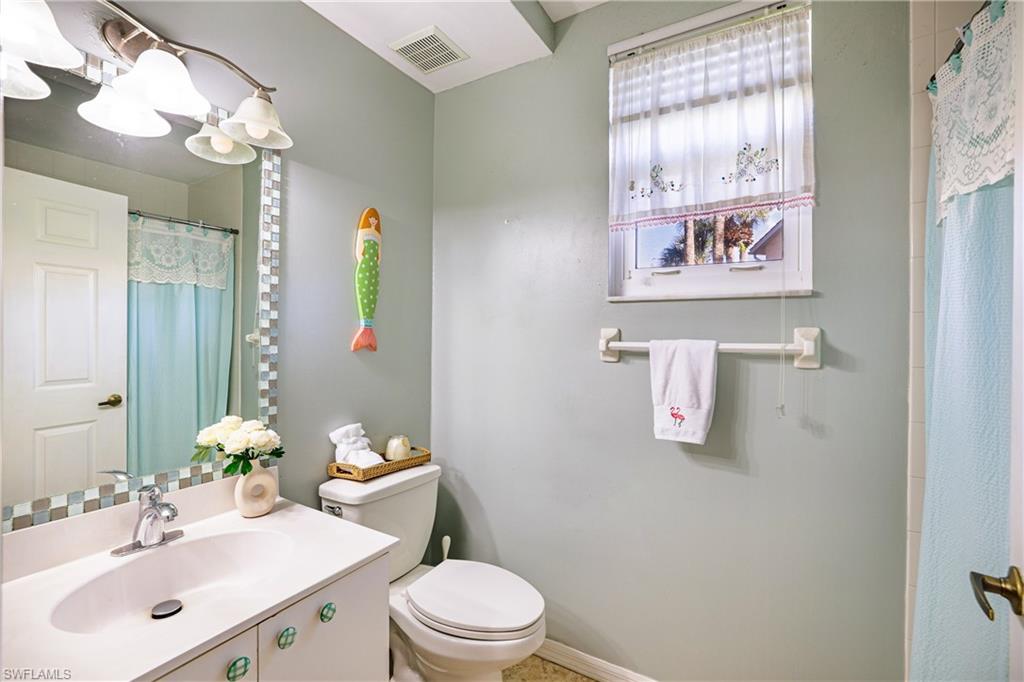 305 Robin Hood Circle, Unit 101 Naples, FL 34104 - Photo 16 of 31 a bathroom with a sink mirror vanity and toilet