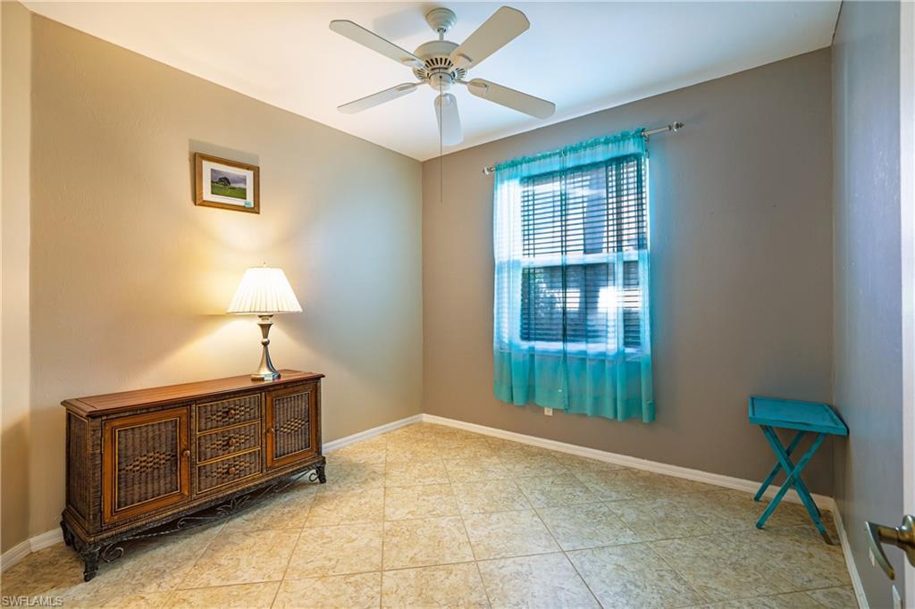 305 Robin Hood Circle, Unit 101 Naples, FL 34104 - Photo 17 of 31 a spacious bedroom with a bed and a table in it