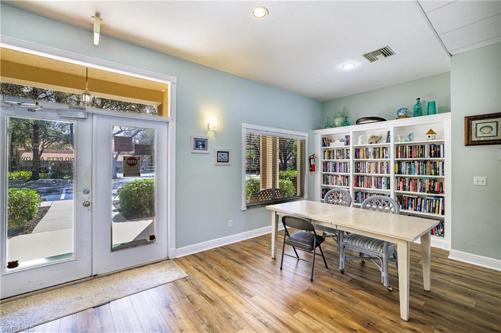 305 Robin Hood Circle, Unit 101 Naples, FL 34104 - Photo 28 of 31 a workspace with furniture window and wooden floor