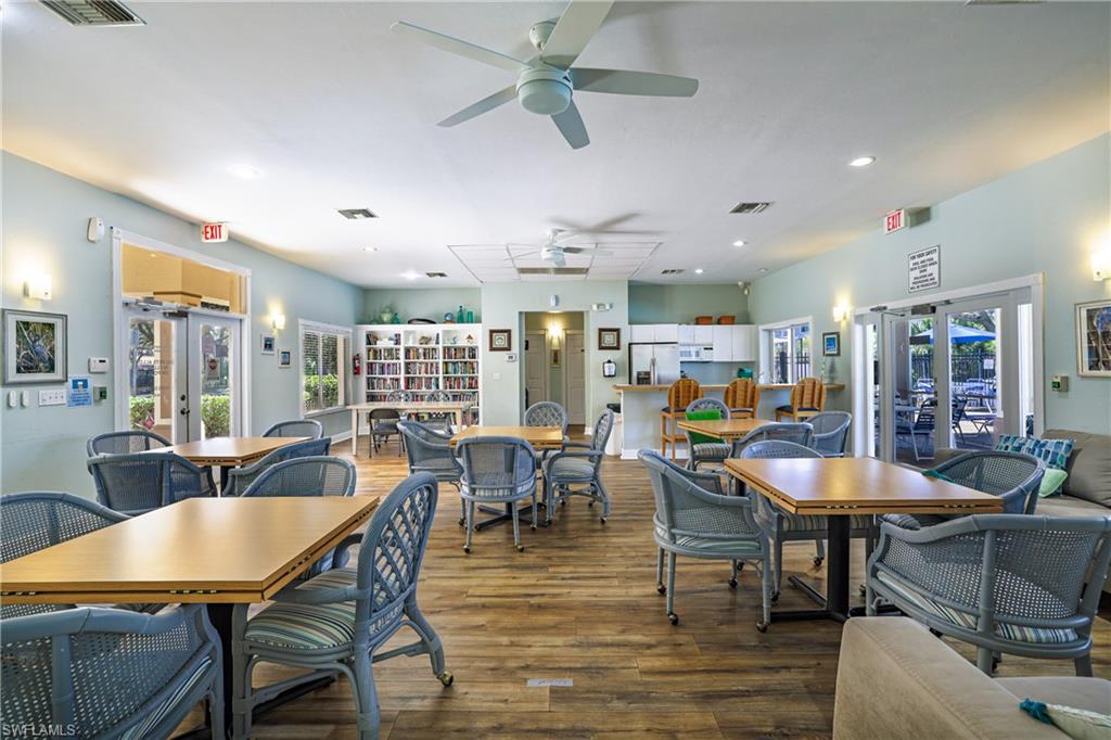 305 Robin Hood Circle, Unit 101 Naples, FL 34104 - Photo 29 of 31 a dining room with furniture a rug and wooden floor