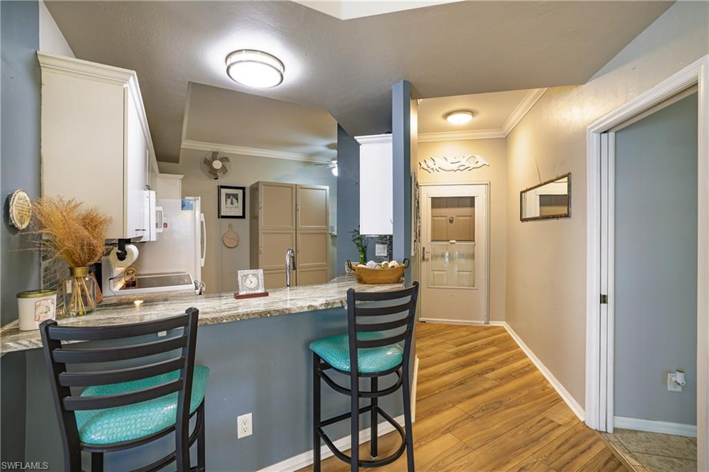 305 Robin Hood Circle, Unit 101 Naples, FL 34104 - Photo 5 of 31 a room with chairs and view of wooden floor