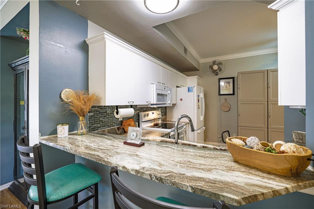 305 Robin Hood Circle, Unit 101 Naples, FL 34104 - Photo 6 of 31 a dining room with table and chairs