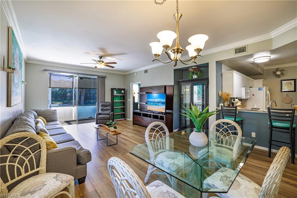 305 Robin Hood Circle, Unit 101 Naples, FL 34104 - Photo 8 of 31 a living room with dining table or chandelier furniture and a large mirror