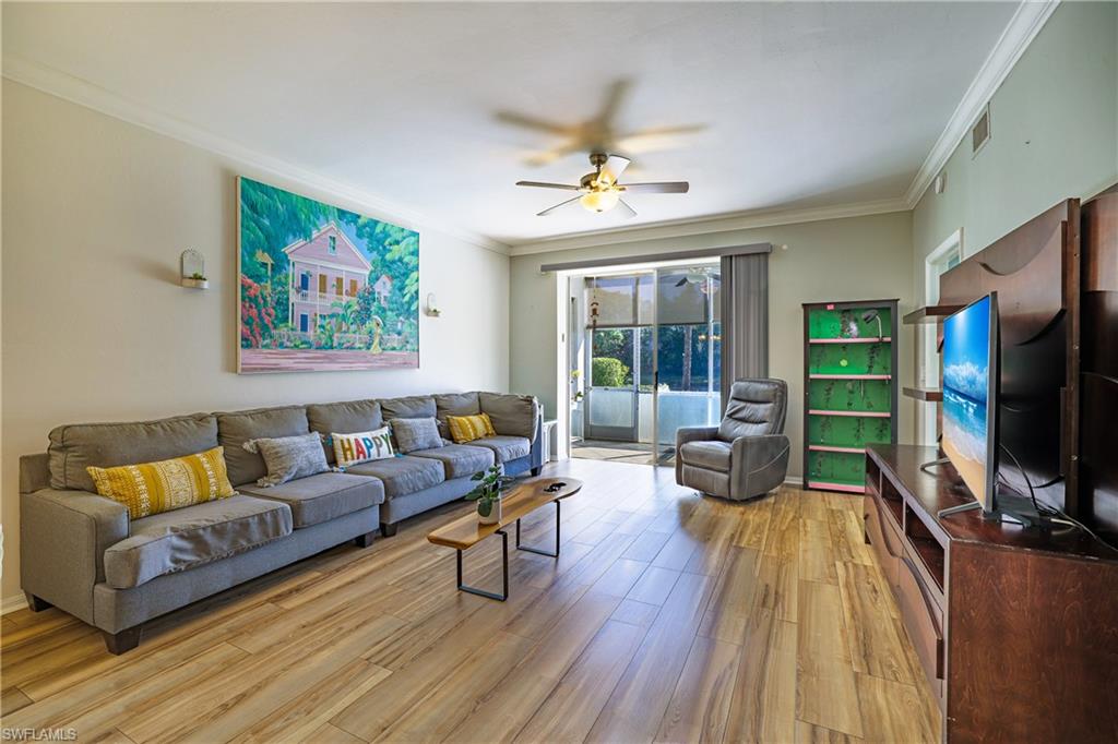 305 Robin Hood Circle, Unit 101 Naples, FL 34104 - Photo 9 of 31 a living room with furniture and a flat screen tv