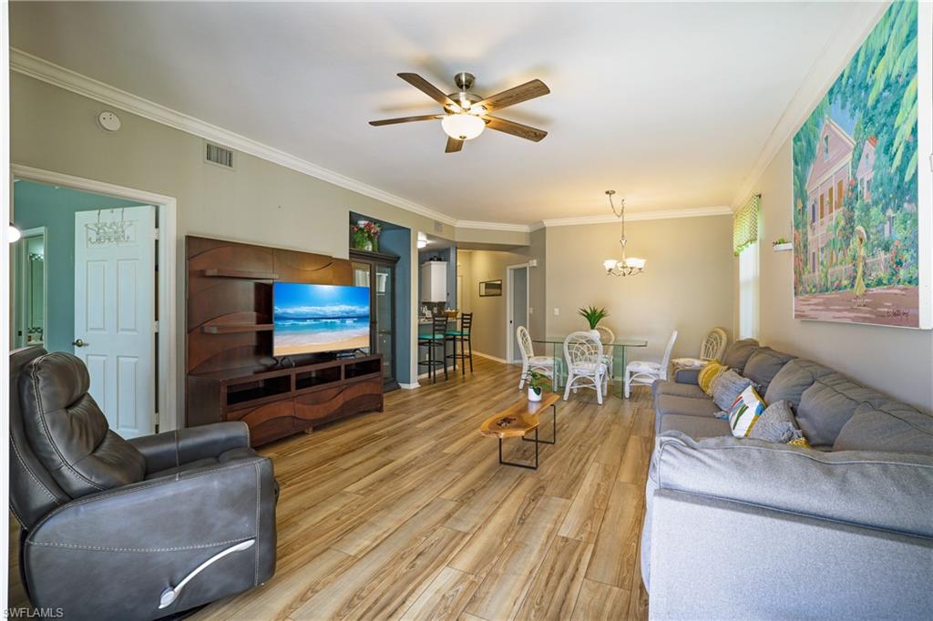 305 Robin Hood Circle, Unit 101 Naples, FL 34104 - Photo 10 of 31 a living room with furniture and a flat screen tv