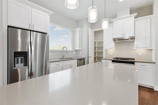 a kitchen with stainless steel appliances white cabinets and a sink