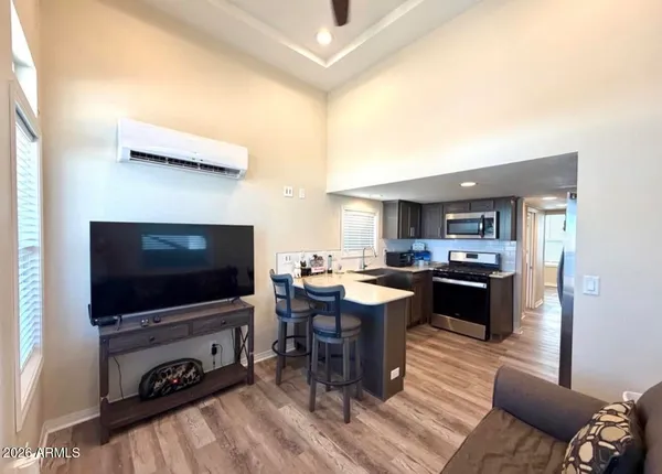 a living room with a flat screen tv kitchen view and a faucet