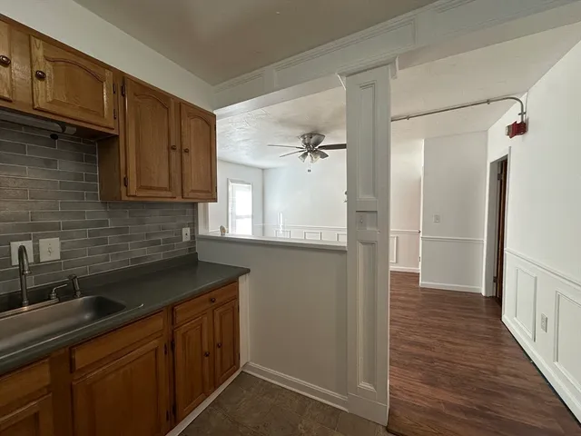 a kitchen with a sink a refrigerator and cabinets
