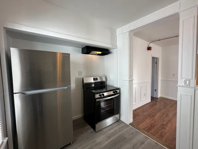 a kitchen with a refrigerator and a stove top oven