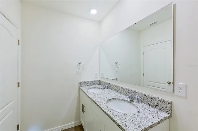 a bathroom with a granite countertop sink and a mirror