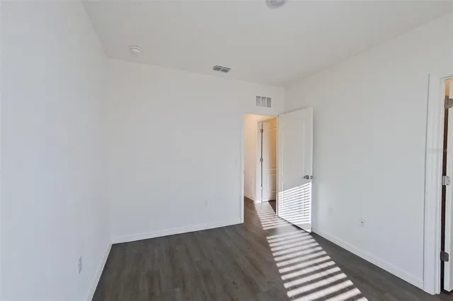 a view of a room with wooden floor and a hallway