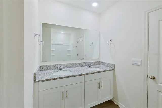 a bathroom with a granite countertop sink and a mirror