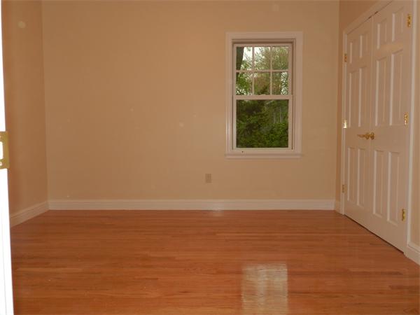 21 Glenland Road, Unit 2 Chestnut Hill, MA 02467 - Photo 20 of 30 a view of an empty room with wooden floor and a window