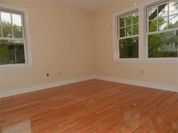 21 Glenland Road, Unit 2 Chestnut Hill, MA 02467 - Photo 23 of 30 a view of an empty room with wooden floor and a window