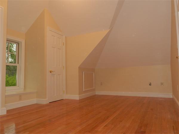 21 Glenland Road, Unit 2 Chestnut Hill, MA 02467 - Photo 24 of 30 a view of an empty room with wooden floor and a window