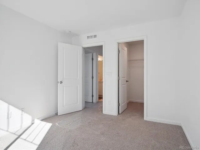 a view of an empty room with closet and a window