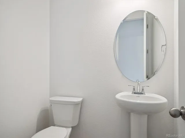 a bathroom with a toilet a sink and mirror