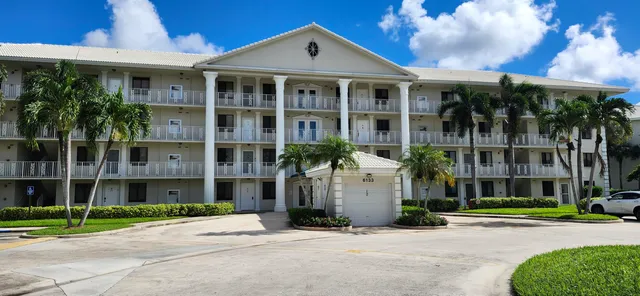 a front view of a building with a garden and plants