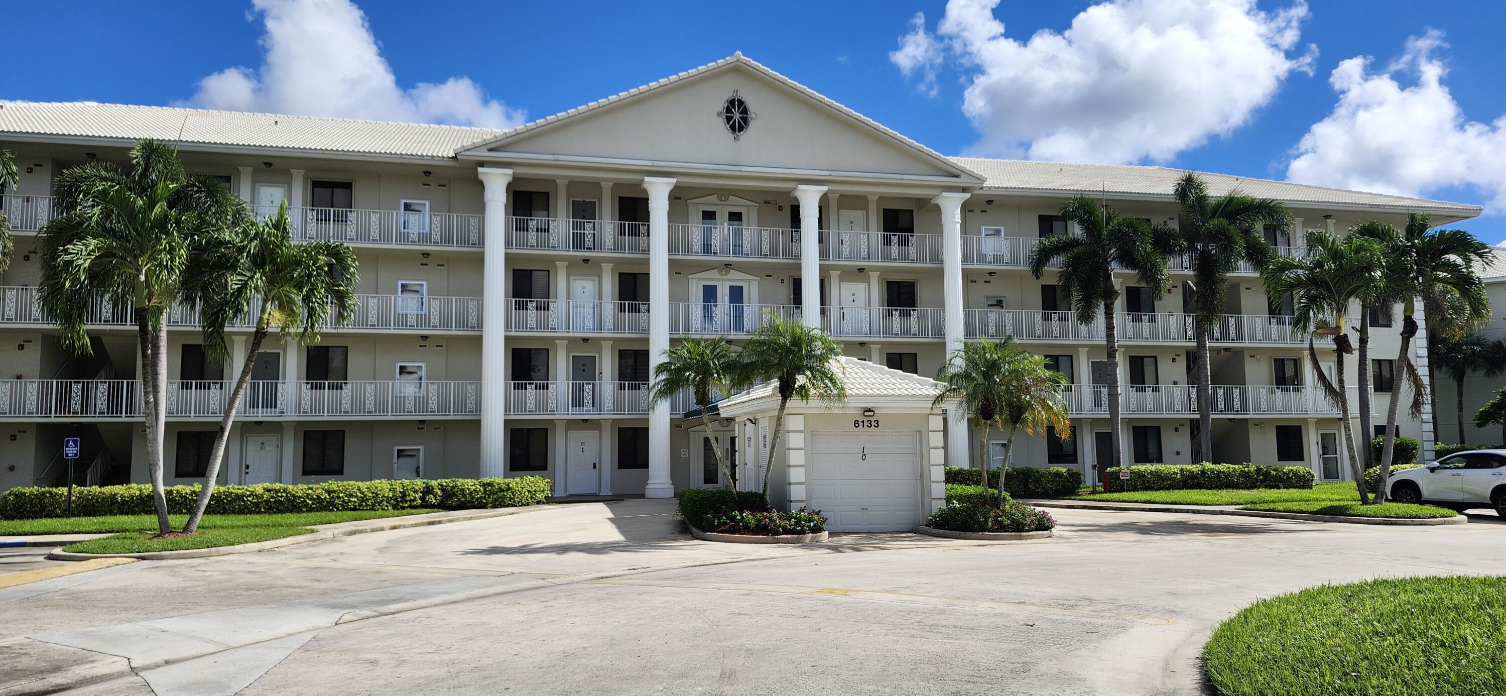 a front view of a building with a garden and plants