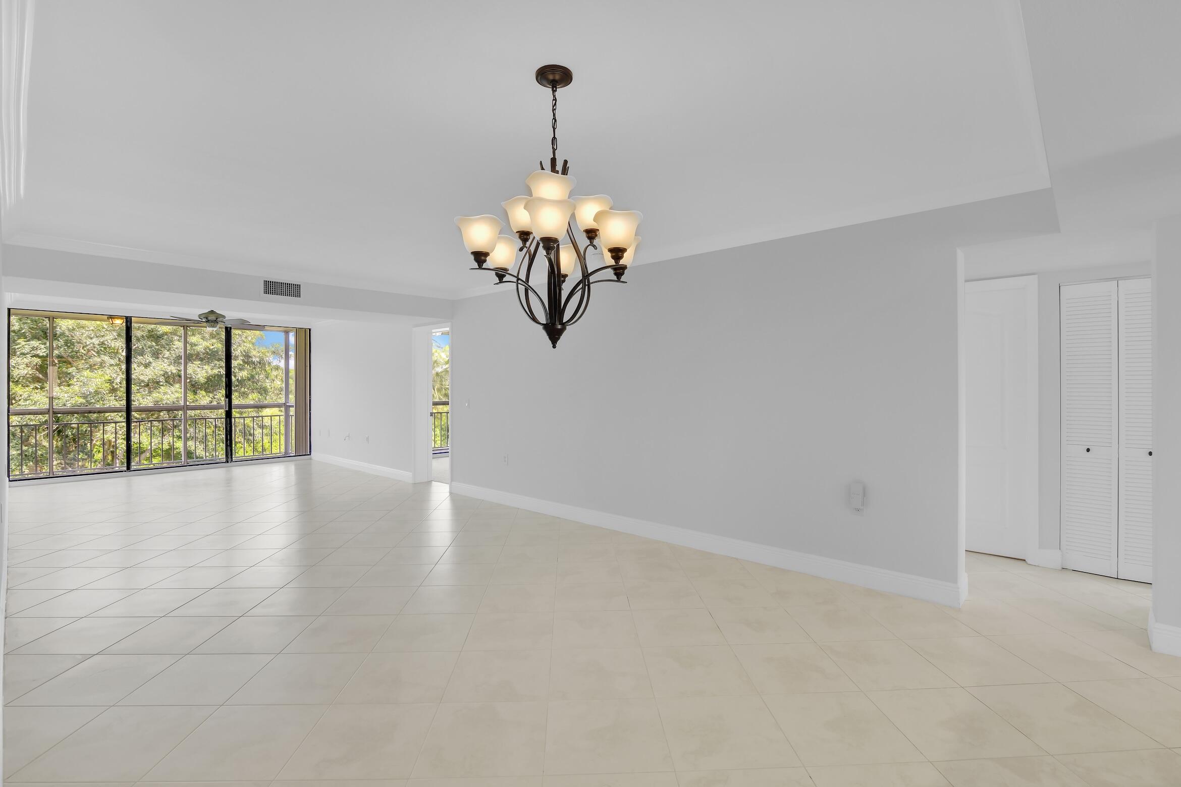 6133 Balboa Circle, Unit 304 Boca Raton, FL 33433 - Photo 14 of 48 a view of a livingroom with a chandelier fan and windows