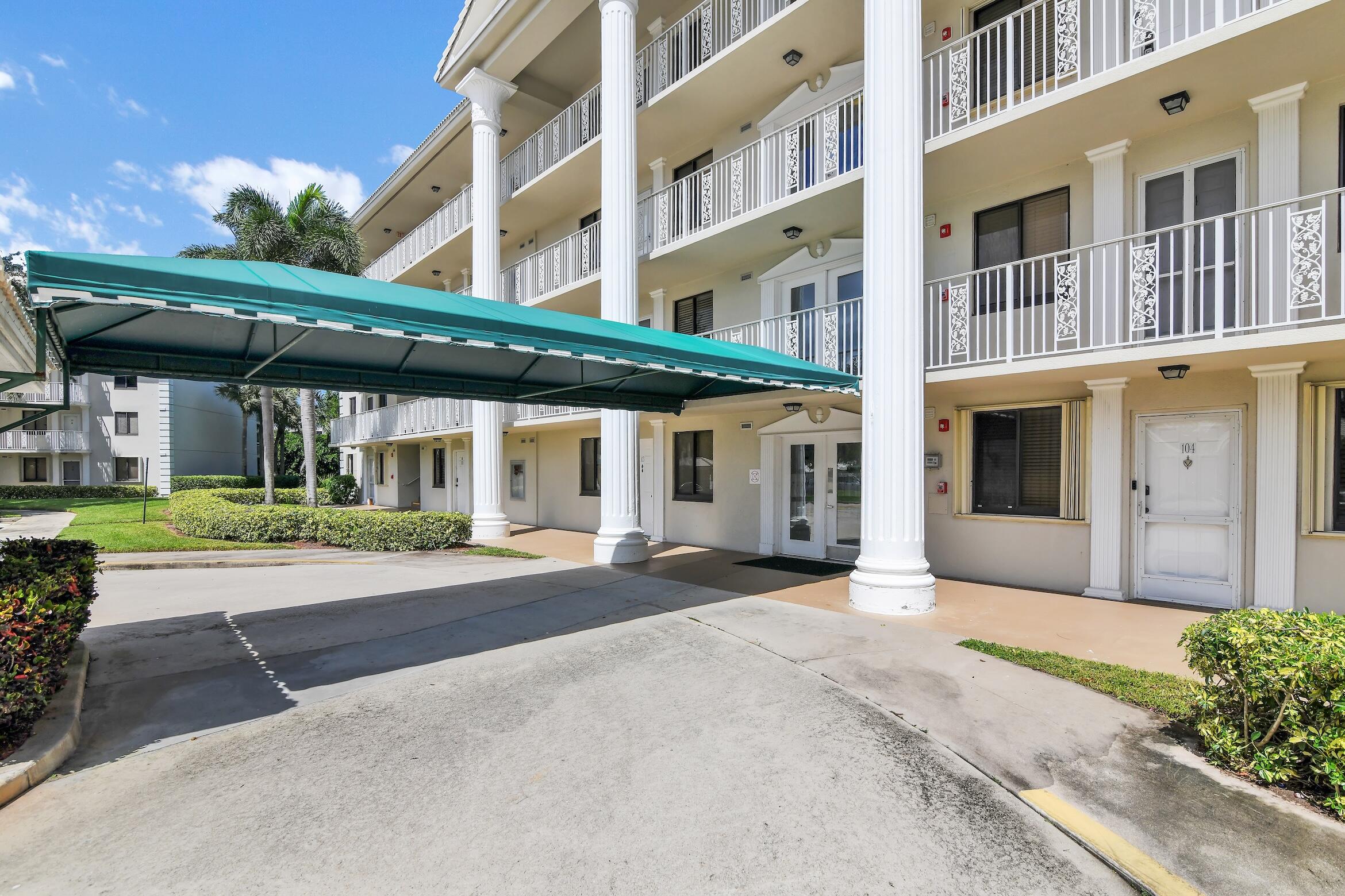 6133 Balboa Circle, Unit 304 Boca Raton, FL 33433 - Photo 2 of 48 a front view of a building with a garden and pathway