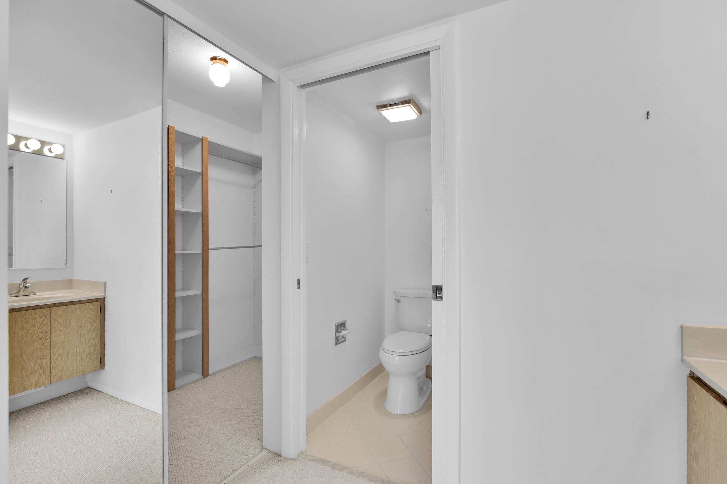 6133 Balboa Circle, Unit 304 Boca Raton, FL 33433 - Photo 36 of 48 a bathroom with a granite countertop sink and a mirror