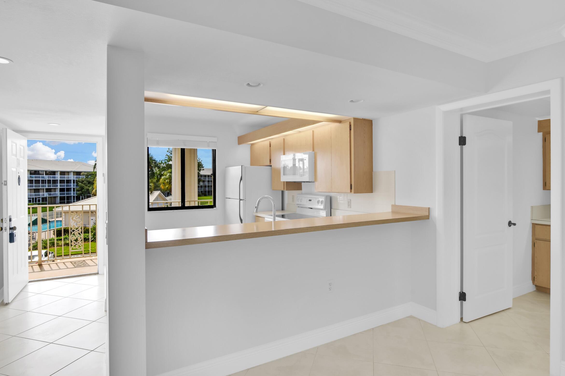 6133 Balboa Circle, Unit 304 Boca Raton, FL 33433 - Photo 8 of 48 a bathroom with a sink and a large mirror