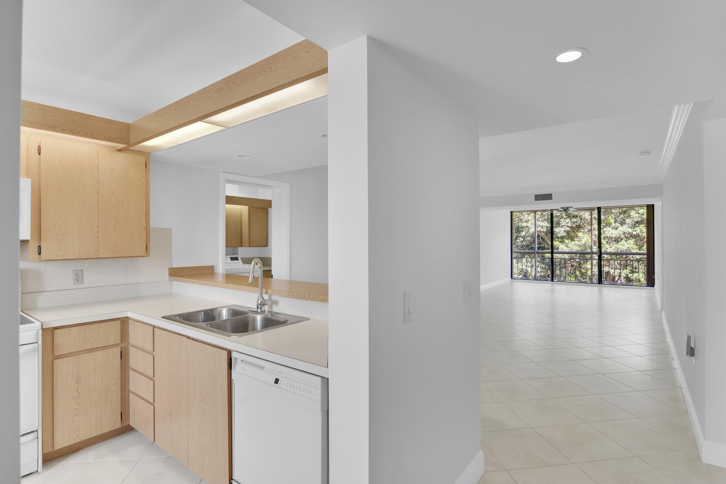 6133 Balboa Circle, Unit 304 Boca Raton, FL 33433 - Photo 10 of 48 a kitchen with a sink cabinets and window