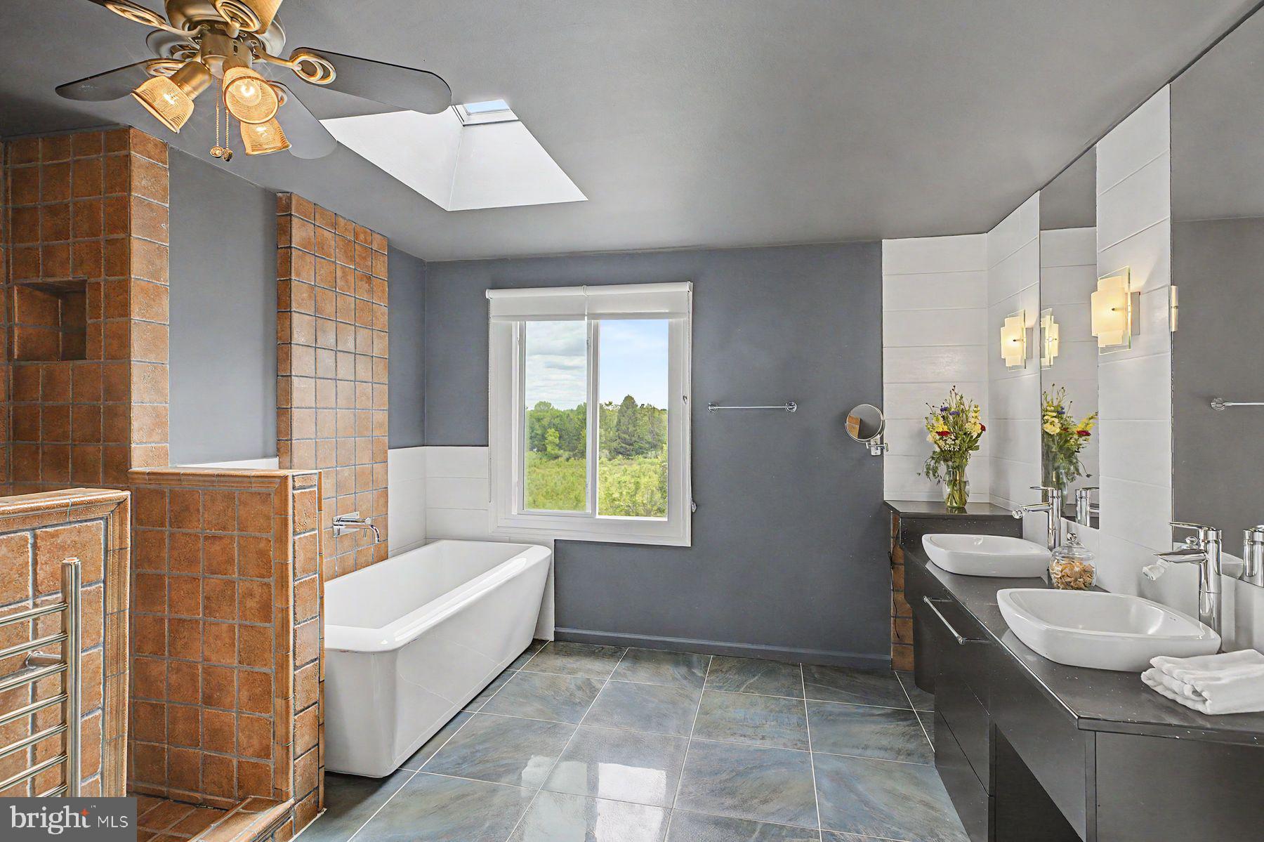 4009 Smoke Road Doylestown, PA 18902 - Photo 34 of 52 a spacious bathroom with a bathtub a sink and a large mirror