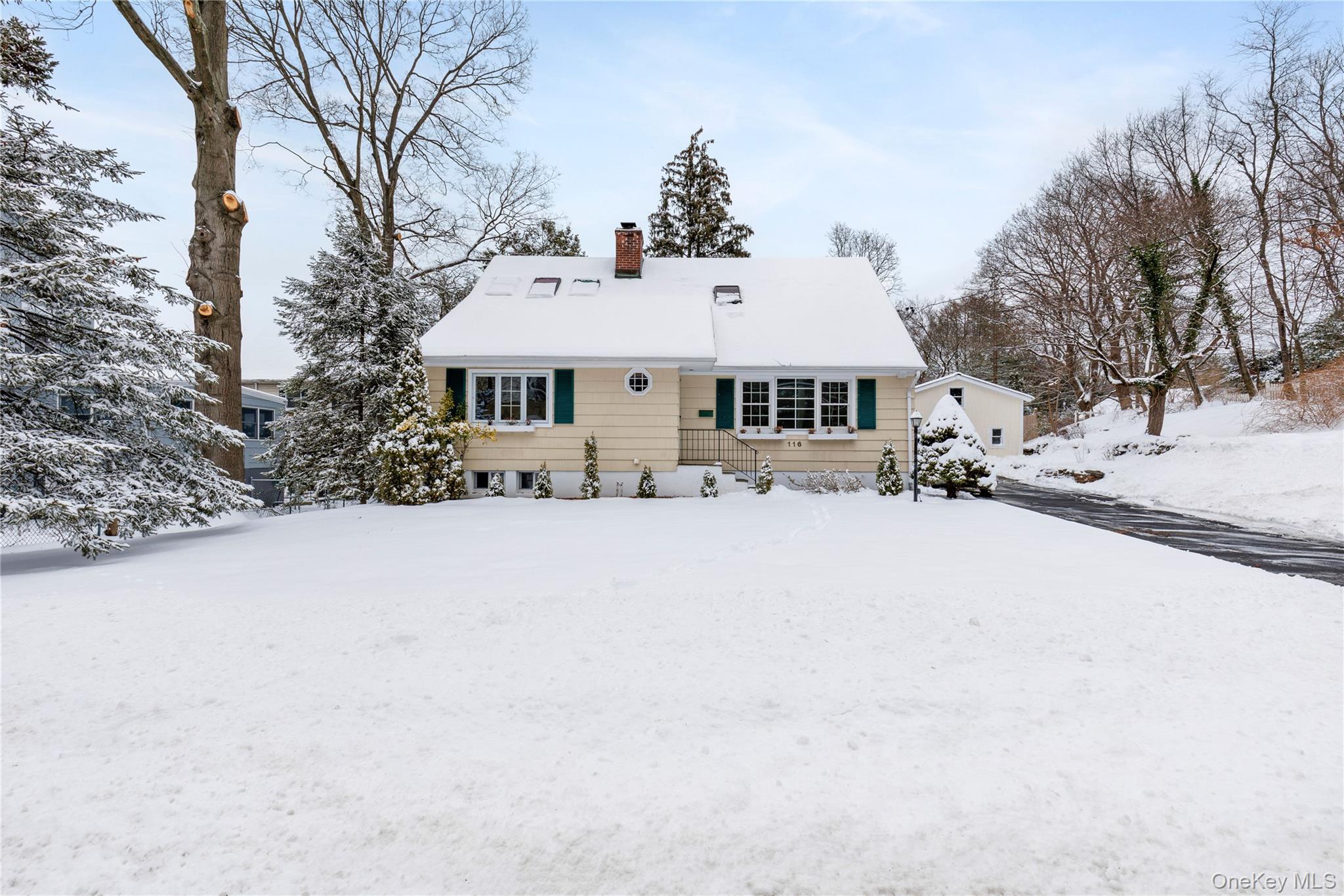 front view of a house with a yard covered in snow