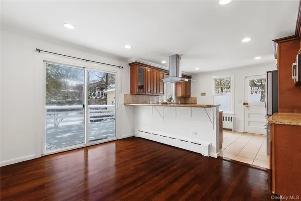 a kitchen with stainless steel appliances wooden floor and a refrigerator
