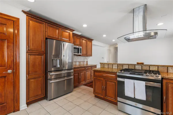 a kitchen with stainless steel appliances granite countertop a stove top oven and cabinets