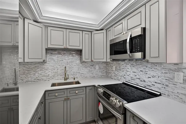 a kitchen with stainless steel appliances granite countertop a sink stove and microwave