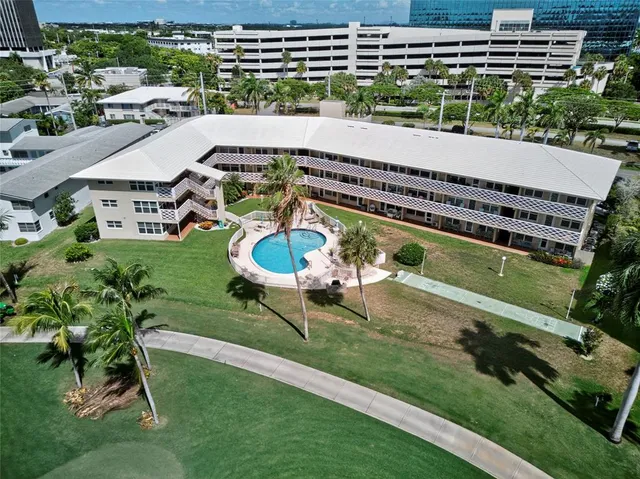 a view of a swimming pool with lawn chairs and plants