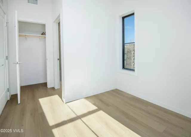 a view of a room with wooden floor and a bathroom