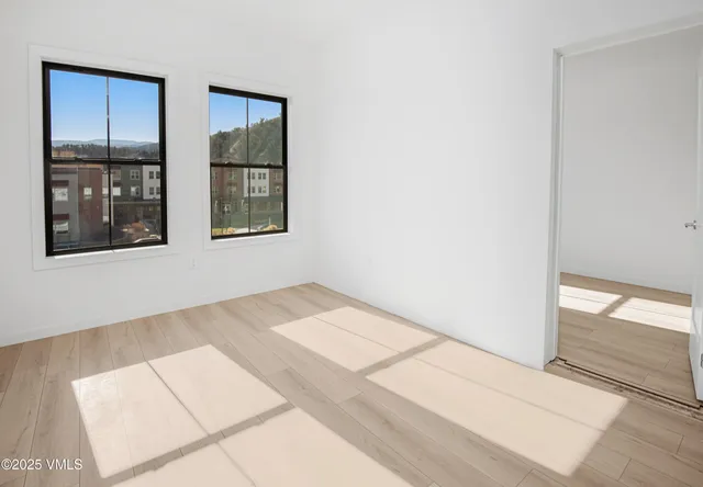 a view of an empty room with window and an entrance