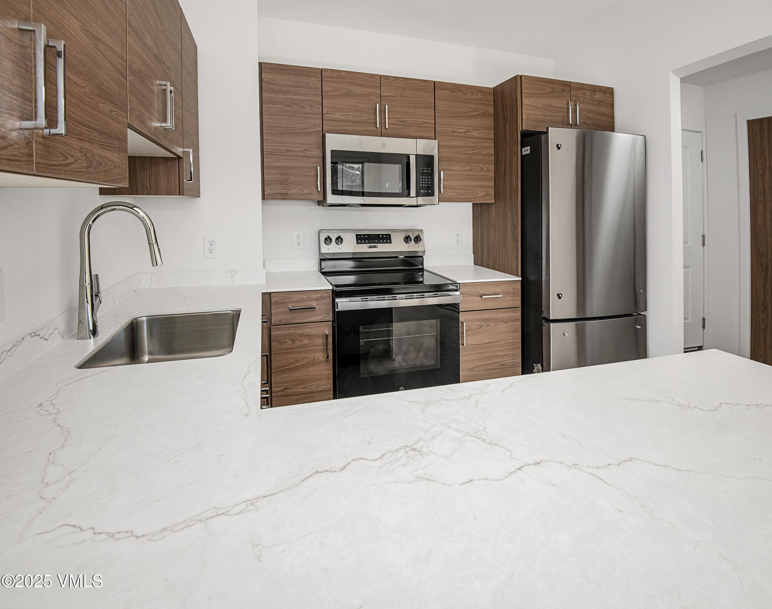 1200 Capitol Street, Unit 101 Eagle, CO 81631 - Photo 4 of 33 a kitchen with stainless steel appliances granite countertop a refrigerator sink and stove