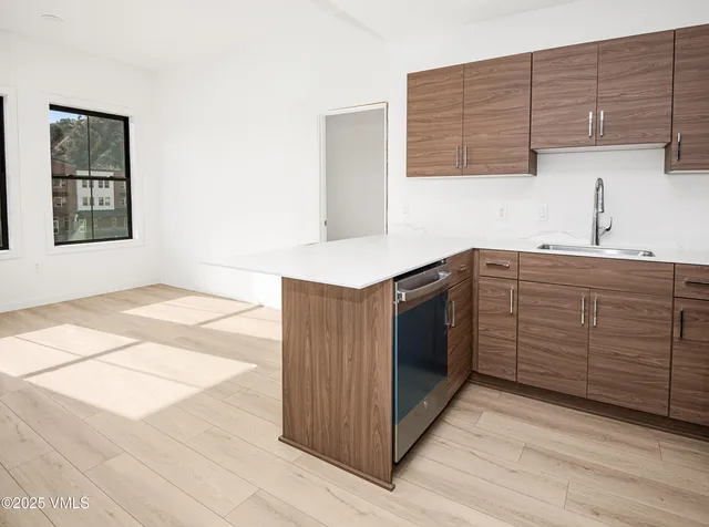 a kitchen with stainless steel appliances kitchen island wooden cabinets a sink and a stove