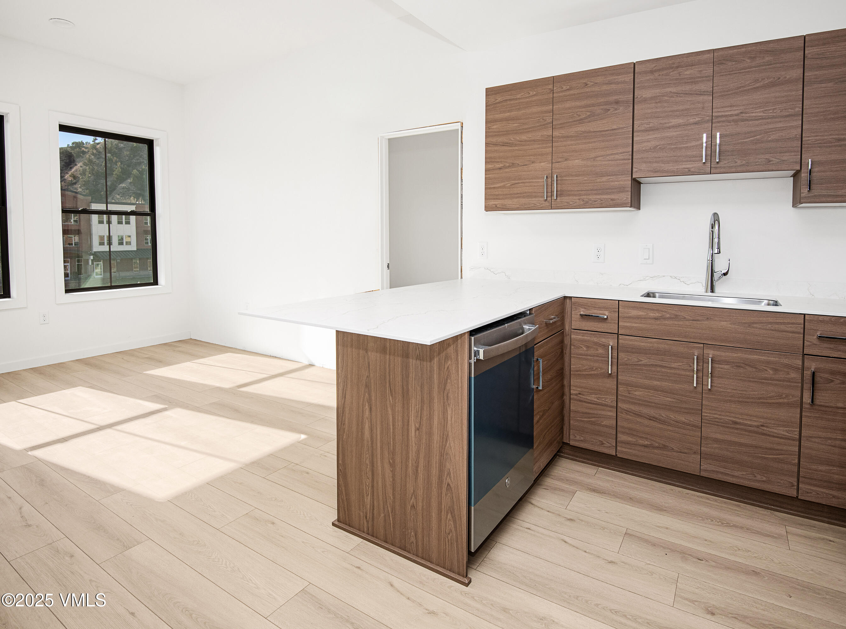 1200 Capitol Street, Unit 101 Eagle, CO 81631 - Photo 5 of 33 a kitchen with stainless steel appliances kitchen island wooden cabinets a sink and a stove