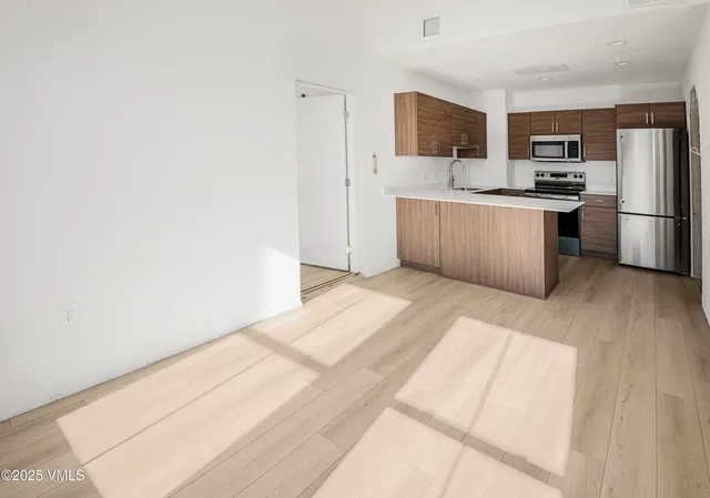 a kitchen with stainless steel appliances a refrigerator and a stove top oven