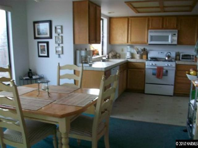 5970 Ridge Lane Reno, NV 89523 - Photo 3 of 9 a kitchen with a table chairs sink and cabinets