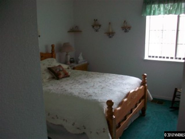 5970 Ridge Lane Reno, NV 89523 - Photo 8 of 9 a bed sitting in a bedroom next to a window