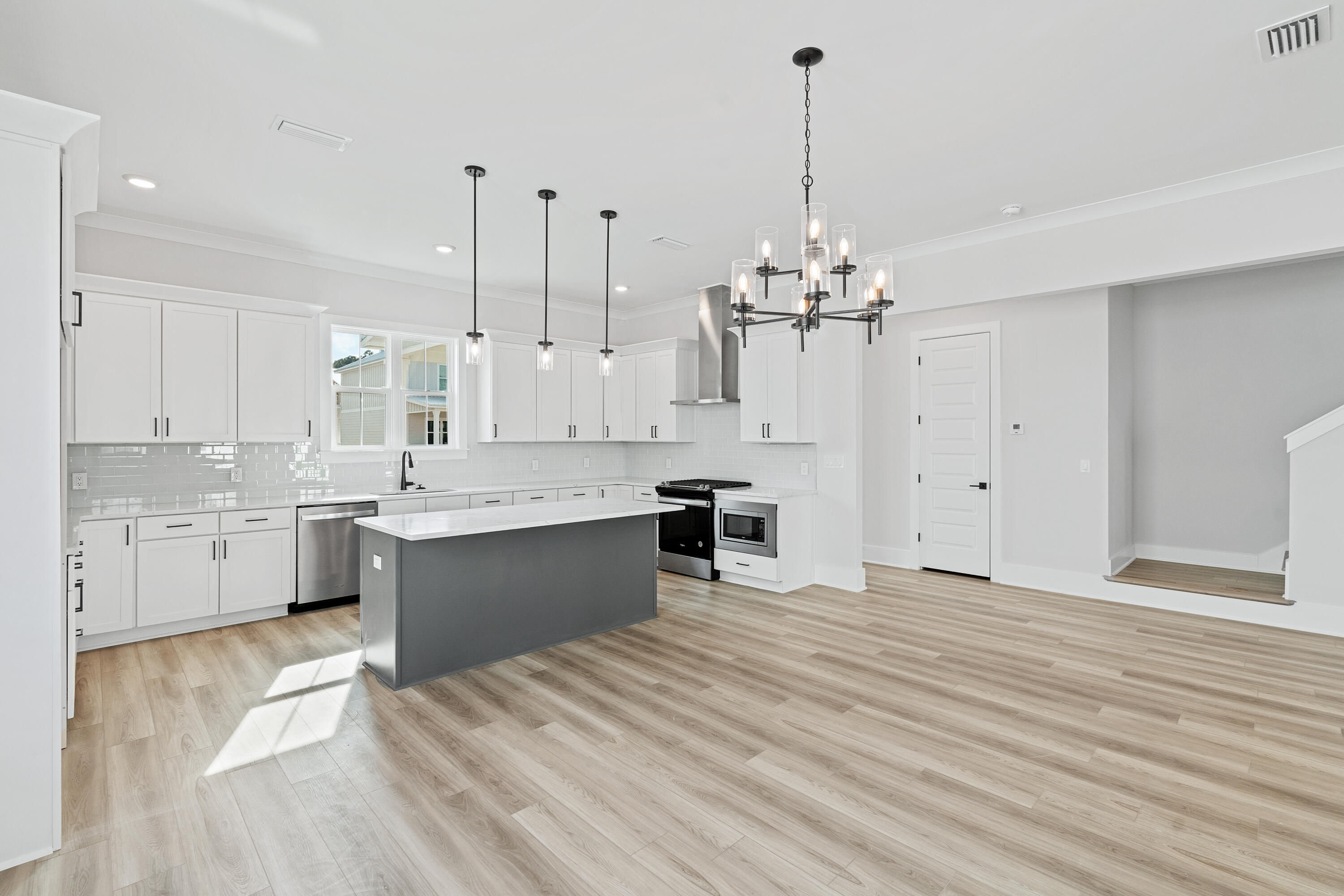 40 Mckenna Way Santa Rosa Beach, FL 32459 - Photo 24 of 61 a large kitchen with kitchen island a sink dishwasher a stove a dining table and chairs with wooden floor