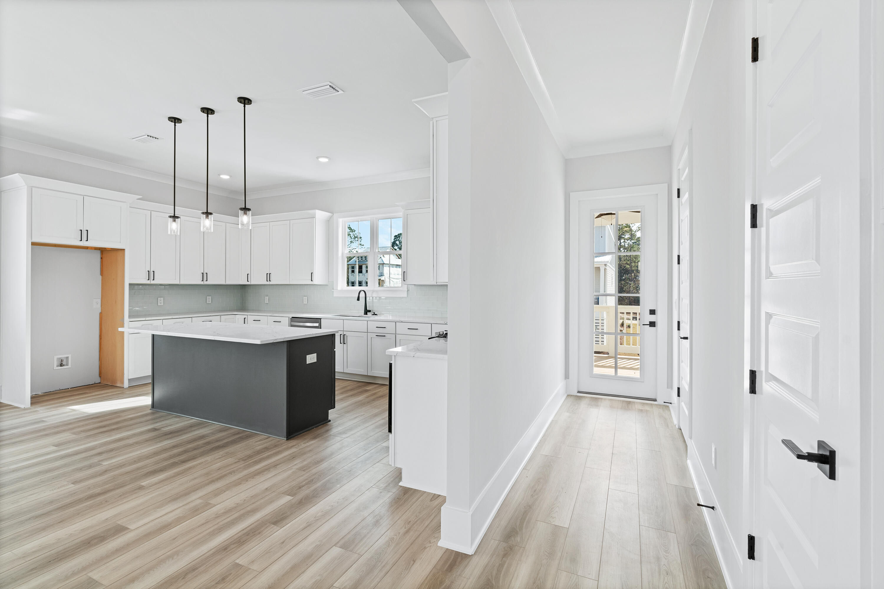 40 Mckenna Way Santa Rosa Beach, FL 32459 - Photo 32 of 61 a large white kitchen with white cabinets and wooden floor